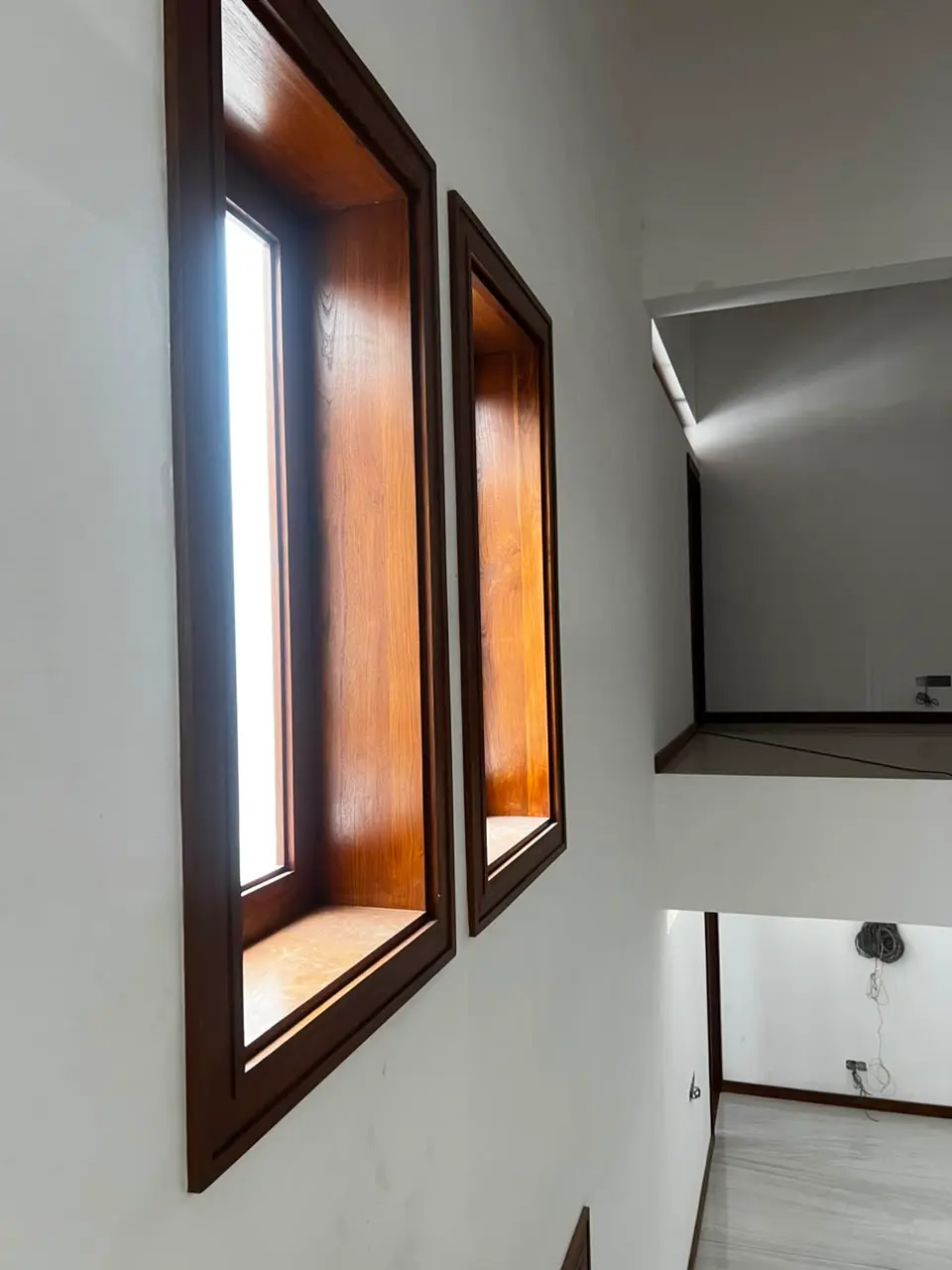Rosmead Place under construction: two deep-set windows in a white wall, beside an open void